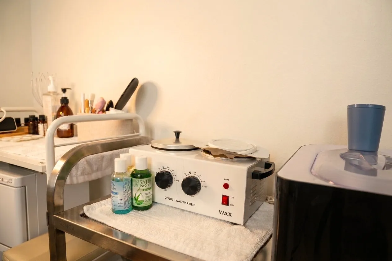 The wax warmer set out on a steel trolley with clean towels and supplies